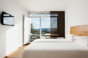 a bedroom with a bed and a large window at Hotel A Miranda in Feás