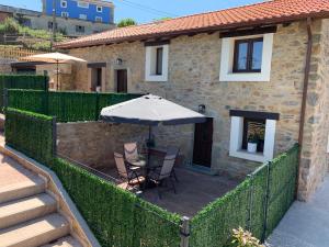 a patio with an umbrella and a table and chairs at Casa Rural Vivienda Vacacional L´Curuxa Complejo CaleaCabo in Biescas