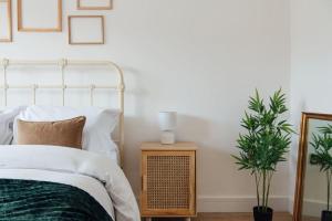 a bedroom with a bed and a table with a plant at Cosy 2 Bedroom Flat in Ilford, London in Ilford