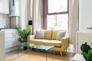 a living room with a couch and a glass table at Cosy 2 Bedroom Flat in Ilford, London in Ilford