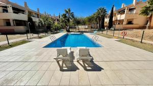 una piscina con tumbonas y una piscina en Sonne - Golf - 4Pers. - Apartments, en Fuente-Álamo de Murcia