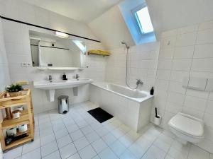 ein weißes Badezimmer mit einer Badewanne und einem Waschbecken in der Unterkunft Apartmány Dlouhá in Tábor