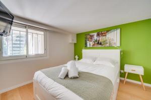 een slaapkamer met een groene muur en een bed bij La Maison ORE - Avec jardin in Bordeaux