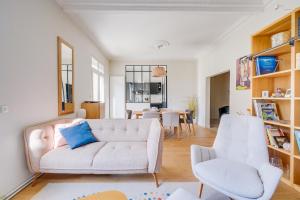 een woonkamer met een bank en 2 stoelen bij La Maison ORE - Avec jardin in Bordeaux