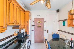 cocina con armarios de madera y mesa con microondas en Neguri Acacias Apartment by Next Stop Bilbao, en Getxo