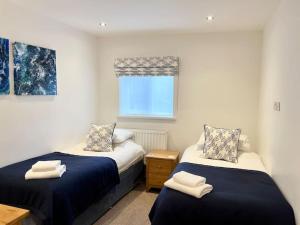 a bedroom with two beds and a window at 8 Standard Street by The Bear Hotel Crickhowell in Crickhowell