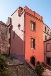 un bâtiment orange avec un éclairage de rue dans l'établissement Dimora Sant'Ignazio Guest House, à Bosa