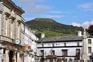 un grupo de edificios con una colina en el fondo en 8 Standard Street by The Bear Hotel Crickhowell, en Crickhowell