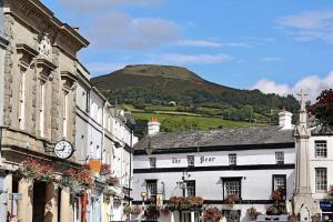 a group of buildings with a hill in the background at 8 Standard Street by The Bear Hotel Crickhowell in Crickhowell