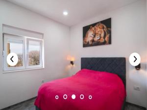 a bedroom with a red bed and two windows at Apartments Andrea in Solin