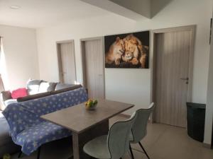 a living room with a table and a lion painting on the wall at Apartments Andrea in Solin