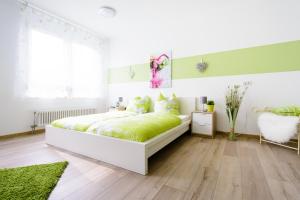 a bedroom with a large bed with green sheets at Breisach City-Appartements in Breisach am Rhein