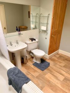 a bathroom with a white toilet and a sink at The Old Granary at Red House Farm in Ripon
