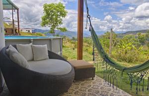 a wicker hammock in a room with a view at Villa Namaste, Cabaña Namaste 1 in Curití
