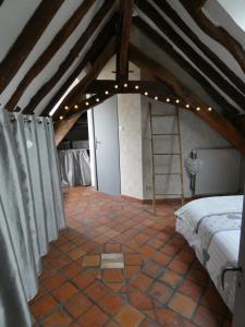 a attic room with a bed and a ladder at Charming house - Beauval - Loire Valley in Saint-Cyran-du-Jambot