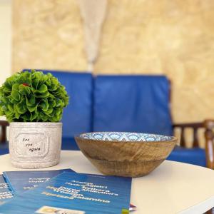 uma mesa com uma tigela e uma planta sobre ela em Hotel Areti em Egina