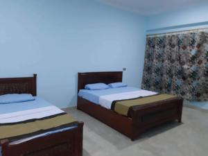 two beds in a room with blue walls at Nile Roof Hotel& Restaurant in Luxor