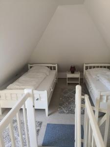 Cette chambre comprend 2 lits blancs dans un escalier. dans l'établissement Karl Sonnenstrahl, à Wulfen auf Fehmarn