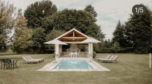 a gazebo with chairs and a swimming pool at Elgin Guest House in Underberg