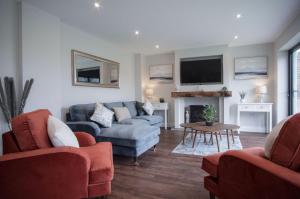 a living room with two couches and a tv at Kiln Park Farmhouse - 4 Bedroom Cottage - Narberth in Narberth