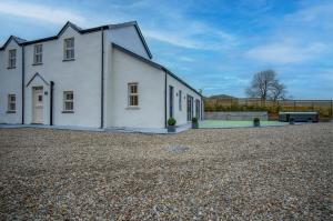 a white building with a bench in front of it at Kiln Park Farmhouse - 4 Bedroom Cottage - Narberth in Narberth