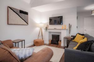a living room with a couch and a fireplace at The Barn At Kiln Park - 2 Bed Cottage - Narberth in Narberth