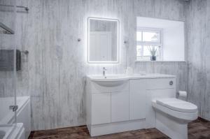 a white bathroom with a sink and a toilet at The Barn At Kiln Park - 2 Bed Cottage - Narberth in Narberth +54 photos