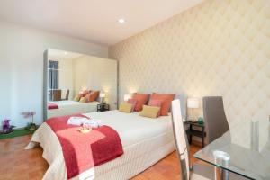 a bedroom with a large white bed with red pillows at Magnificent Sunny Flat - Douro River in Vila Nova de Gaia