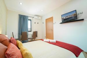 a bedroom with a bed and a tv on the wall at Magnificent Sunny Flat - Douro River in Vila Nova de Gaia