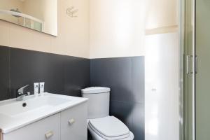 a bathroom with a white toilet and a sink at Magnificent Sunny Flat - Douro River in Vila Nova de Gaia +32 photos