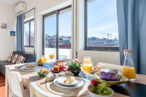 a dining room table with food and drinks on it at Magnificent Sunny Flat - Douro River in Vila Nova de Gaia
