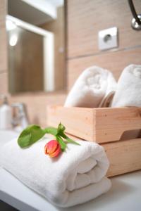 a bathroom with towels and a flower on a counter at CLOUD APARTMENTS DUBROVNIK in Dubrovnik