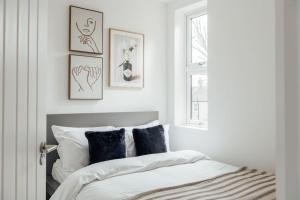 una camera da letto con un letto con cuscini bianchi e neri di Modern 2 Bedroom Flat in Ilford, London a Ilford