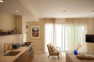 a kitchen with a sink and a couch in front of a window at Vila Rodrigues in Lisbon