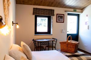 Schlafzimmer mit einem Bett, einem Tisch und einem Fenster in der Unterkunft Casa Terraços do Lobo in Manteigas