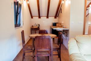 a small kitchen with a table and chairs in a tiny house at Casa Terraços do Lobo in Manteigas