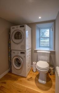 a bathroom with a washing machine and a toilet at Portree, Isle of Skye in Portree