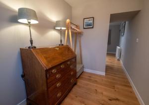 a room with a dresser with a lamp and a hallway at Portree, Isle of Skye in Portree