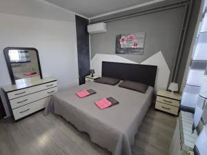 Un dormitorio con una cama con dos tarjetas rosas. en Apartment Ari, en Rovinj