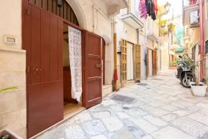 an alley with an open door on a building at Charming Old Town House in Bari