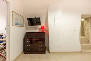 a room with a dresser with a tv on a wall at Charming Old Town House in Bari