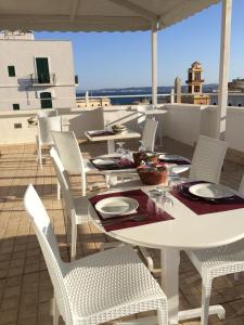 een witte tafel en stoelen op een dak bij Hotel Città Bella in Gallipoli