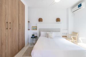 セビリアにあるVeoapartment Alfareríaのベッドルーム1室(白い大型ベッド1台、木製キャビネット付)
