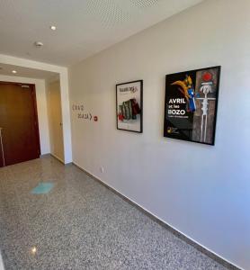 a hallway with three pictures on a wall at Hôtel La Falaise in Cotignac