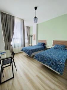 a hotel room with two beds and a desk at Arabesque Hotel in Amman