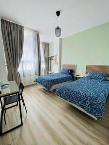 a hotel room with two beds and a table and a desk at Arabesque Hotel in Amman