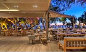 アテネにあるEcoStay - Infinity business class 2BDR apartment by the sea in Alimosの水辺の景色を望むテーブルと椅子付きのレストラン