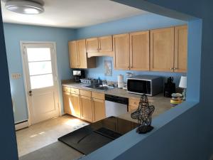 a kitchen with wooden cabinets and a counter top at Beach Front on the Bay in our Rustic, Pet Friendly Cottage home in North Camellia Acres +66 photos
