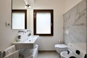 アルバタックスにあるAmazing view – Beautiful Apartment Portu Frailisの洗面台とトイレを備えた白いバスルーム +27枚の写真