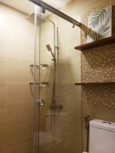 y baño con ducha y aseo. en Adria Residences - Emerald Garden - 2 Bedroom Unit for 4 person, en Manila